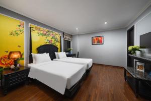 a hotel room with two beds and a fireplace at Amara Hanoi Hotel and Spa in Hanoi