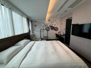 a bedroom with a large bed and a television at Rich & Free Hotel - Zhongshan in Taipei