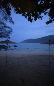 due ombrelloni seduti su una spiaggia di notte di Rustic apartment at YaNui beach a Phuket