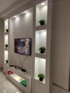 ein Wohnzimmer mit einem TV an der Wand in der Unterkunft Studio meublé à bas prix (salon, chambre, douche, cuisine) in Yasika