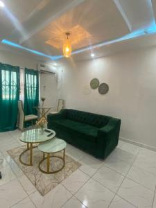 ein Wohnzimmer mit einem grünen Sofa und einem Tisch in der Unterkunft Studio meublé à bas prix (salon, chambre, douche, cuisine) in Yasika