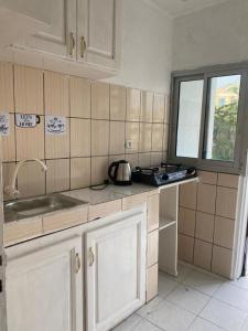 eine Küche mit einem Waschbecken und einem Fenster darin in der Unterkunft Studio meublé à bas prix (salon, chambre, douche, cuisine) in Yasika