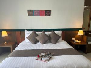 Siam Triangle Hotel tesisinde bir odada yatak veya yataklar