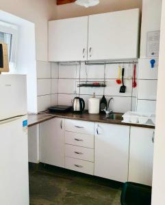 a kitchen with white cabinets and a white refrigerator at ARANY13 Apartmanház - Mówimy po polsku! in Bogács +16 photos