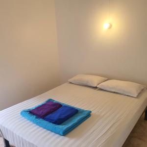 uma cama branca com uma toalha azul em 8 homestel em Ko Tao