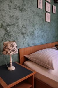 a bedroom with a bed and a table with a lamp at Studio apartment Laura-spacious studio on the main beach in Makarska