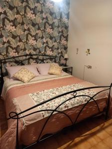 una camera da letto con un letto e carta da parati floreale di MERIDIAN HOUSE LECCO a Lecco