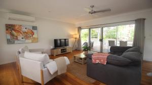 a living room with a couch and a tv at Le Belle Aimante, Magnetic Island in Horseshoe Bay