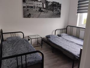 duas camas num quarto com uma fotografia na parede em LUX Apartament em Chrzanów