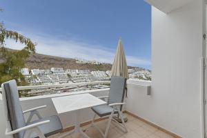 a balcony with a table and chairs and a view at Enjoy in Puerto Rico de Gran Canaria