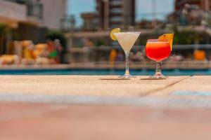 dois cocktails sentados numa mesa ao lado de uma piscina em Port Fiesta Park em Benidorm