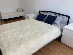 a bedroom with a large white bed with blue pillows at Nameja Best view apartamenti in Jēkabpils