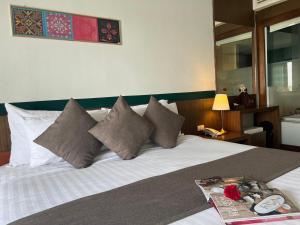 Una cama en una habitación de hotel con una bandeja. en Siam Triangle Hotel, en Chiang Saen