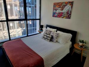 a bedroom with a large bed with pillows on it at High Rise Unit in front of Crown with Free Parking in Melbourne