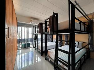 Bell Lifestyle Hostel Phuket في شاطئ ناي يانغ: غرفة مع ثلاثة أسرة بطابقين في غرفة