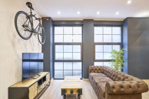 una sala de estar con sofá y una bicicleta en la pared en Loft diseño el taller del abuelo con parking en Salamanca