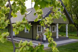 una casa verde con tetto di gambero di Medsedis Plateliai a Plateliai