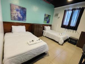 a room with two beds in a room at The Colonial Residences Angeles City in Angeles +28 photos