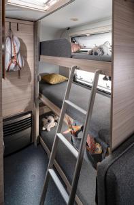 a room with two bunk beds and a ladder at VogtlandCAMPING in Markneukirchen