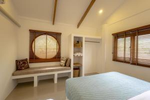 a bedroom with a bed and a window with a bench at Neverland in Koh Phangan