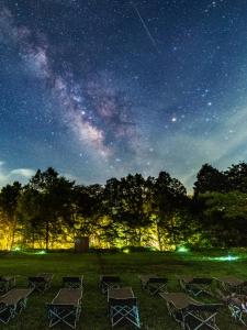 een groep stoelen in een veld 's nachts bij Minami Aso Luna Observatory Auberge Mori no Atelier in Minami Aso
