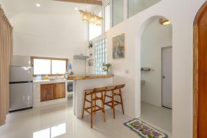 a kitchen with white walls and a counter with stools at Neverland in Ko Phangan