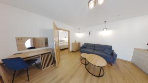 salon z niebieską kanapą i stołem w obiekcie Apartament ARKA w mieście Jarosławiec