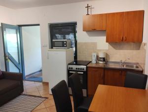 a kitchen with a white refrigerator and a table at Apartment Keti in Čižići +6 photos