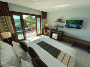 a bedroom with a bed and a television and a balcony at Siam Triangle Hotel in Chiang Saen