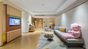 a living room with a couch and a tv at Holiday Inn Chongqing Guanyinqiao by IHG in Chongqing