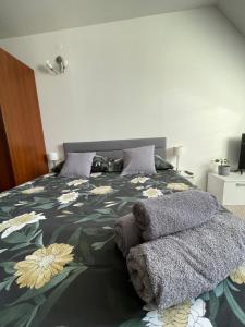 a bedroom with a bed with a flower patterned blanket at Willa Kosówka - Frydman in Frydman