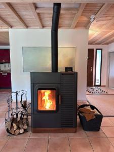 a fireplace in a living room with a stove at Unique Sustainabel Lodge in the Swiss Jura Mountains in Neuchâtel