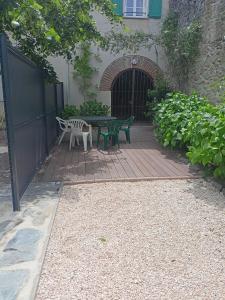 une terrasse avec une table et des chaises devant un bâtiment dans l'établissement Gîte de charme la belle histoire, à Prades