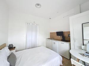 una camera bianca con letto e scrivania di Domaine Le Clos Lassagne a Brignais
