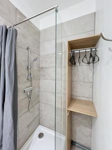 een douche met een glazen deur in de badkamer bij Domaine Le Clos Lassagne in Brignais