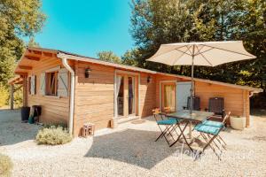 GroléjacにあるCottage O' Temps de Vivreの木造のキャビン(テーブル、傘付)