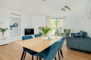 a living room with a wooden table and blue chairs at Apartment in Pobierowo near Baltic Beach in Pobierowo