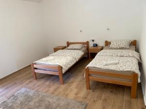 2 aparte bedden in een kamer met houten vloeren bij Camping Oaza in Bela Crkva