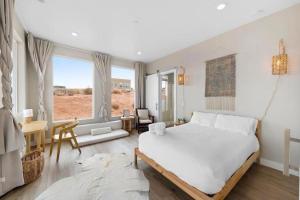1 dormitorio con 1 cama blanca, mesa y sillas en Tranquil Zen Retreat with Amazing Mesa Views, en Big Water