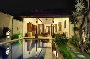 a house with a swimming pool in the yard at Puri Mas Boutique Resort & Spa in Senggigi