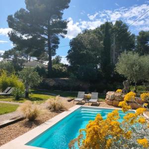 a swimming pool in a garden with flowers at La Villa Aux Oliviers in Flayosc