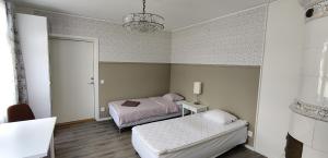 1 Schlafzimmer mit 2 Betten und einem Kronleuchter in der Unterkunft Villa Nostan in Nybro