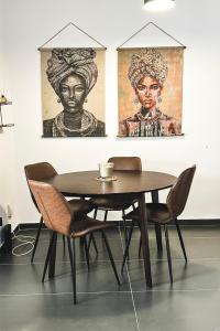 un tavolo e sedie in una stanza con dipinti di Home Away One Bedroom Apartment in Nicosia a Nicosia