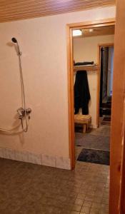 Habitación con baño con ducha y pasillo. en Lapland Old School en Muonio