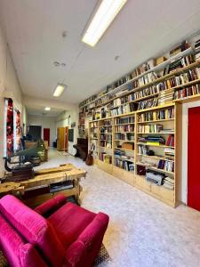 una gran biblioteca con un sofá rojo y estanterías en Lapland Old School, en Muonio