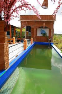 a pool of water in front of a house at Cần Thơ Farmstay in Can Tho