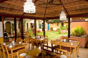 a restaurant with wooden tables and chairs and a pavilion at Casa Cottage in Bangalore