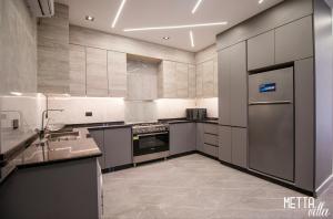 a kitchen with stainless steel appliances and a sink at Metta Villa in Al Rama