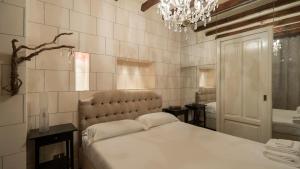 Un dormitorio con una cama grande y una lámpara de araña. en Italianway-Argelati 12, en Milán