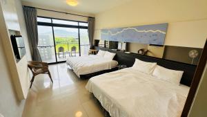 um quarto de hotel com duas camas e uma janela em Butterfly B&B em Manzhou mais 38 fotografias